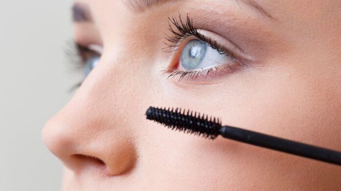 melhor máscara de cílios a prova d'água - foto de capa (1) Fotografia de moça passando rímel em close, utilizada para ilustrar artigo sobre a melhor máscara de cílios à prova d'água.
